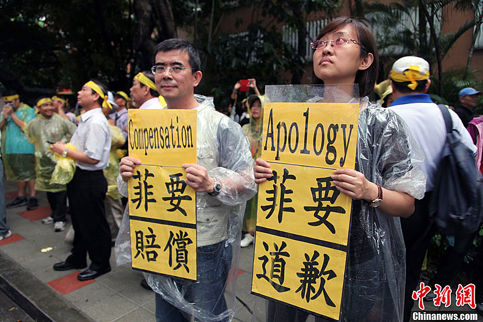 　圖為當(dāng)天下午，當(dāng)臺灣數(shù)百漁民在馬尼拉經(jīng)濟(jì)文化辦事處前抗議時，有兩名年輕人手持標(biāo)語，在路邊聲援。中新