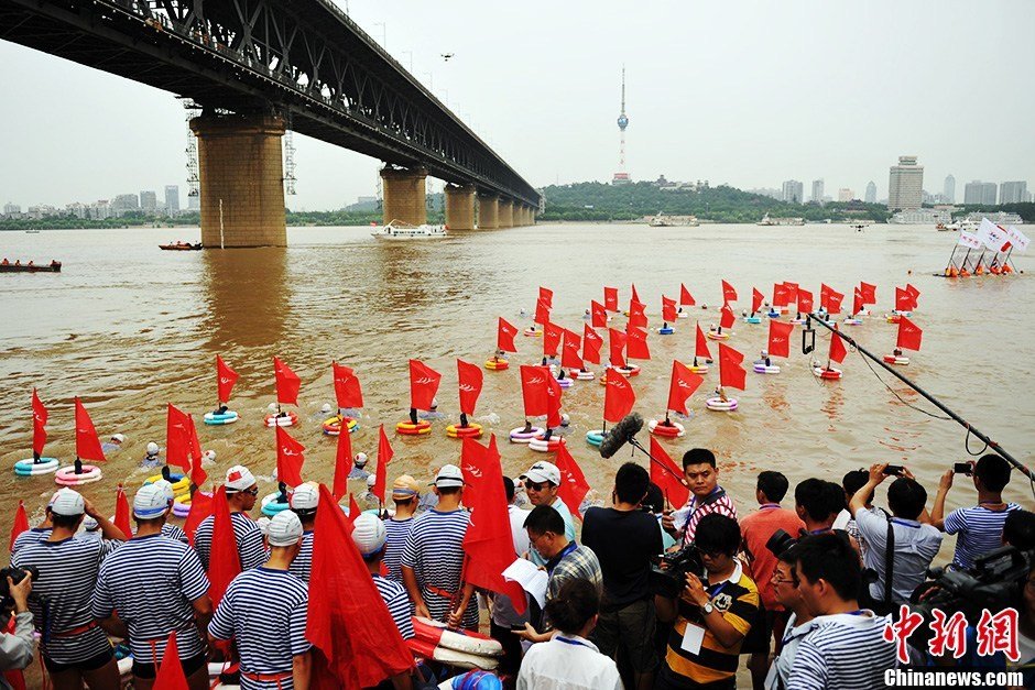 圖為江面上的橫渡方隊(duì)里的選手們劈波斬浪。中新社發(fā) 張暢 攝