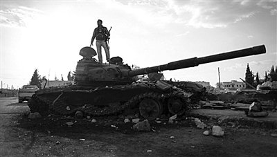 9月8日，敘利亞Zabadani，一名敘利亞反對派武裝人員站在廢棄的政府軍坦克上。