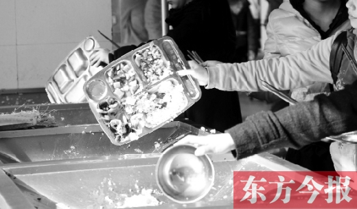 11月27日，河南中醫(yī)學(xué)院餐廳，一名同學(xué)將餐盤內(nèi)沒吃完的食物倒入餐具回收車內(nèi)
