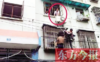 施救現(xiàn)場，劉鵬（圈內(nèi)）先用繩子捆住老太確保安全 勞動報記者 郭娜 供圖