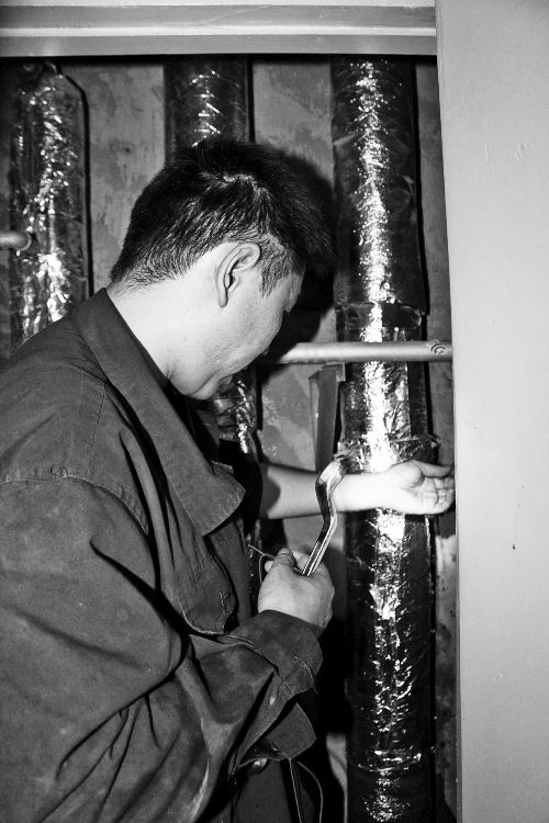 苗師傅一邊進(jìn)行維修，一邊用耳機(jī)接聽市民的電話。