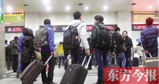 鄭州火車站東廣場(chǎng)售票大廳，幾名學(xué)生在售票窗口前躊躇