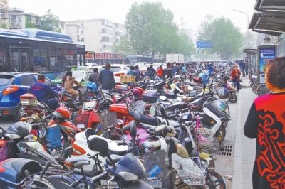 省人民醫(yī)院北門，路邊的公交站牌處停滿非機動車，上、下客只能在快車道上。