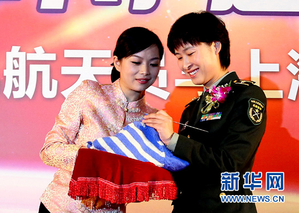 11月1日，航天員劉洋（右）在為“愛心”毛衣編織最后的收尾針。