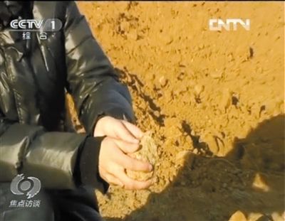 麻剛沙系麻剛石粉碎而成。記者找到一塊麻剛石，一捏就碎成粉末，硬度非常差。央視截圖