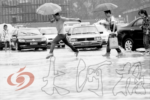 鄭州經(jīng)三路與北環(huán)交叉口處，積水較深，行人們不得不“練輕功”。 記者 白周峰 攝影