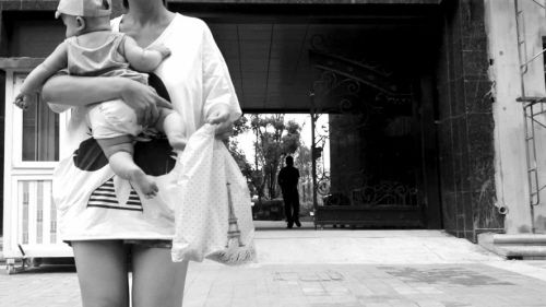 抱著孩子出售人奶的女子。