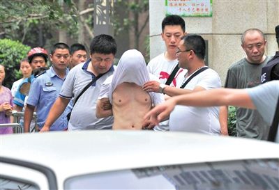昨日，成都警方抓捕時與毒犯發(fā)生槍戰(zhàn)。一名男犯罪嫌疑人被警方押出。