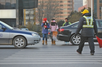 過(guò)斑馬線，行人左顧右盼，汽車寸土必爭(zhēng)。