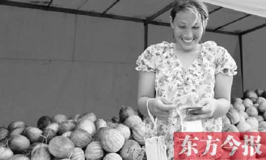 昨日，開封瓜農(nóng)史瑩瑩幸福地?cái)?shù)著賣瓜錢