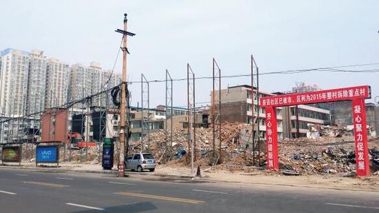 015年5月31日，在社區(qū)干部的帶頭拆遷下，親賢社區(qū)的“城中村改造”拉開(kāi)帷幕。由于前期“清產(chǎn)核資”及補(bǔ)償標(biāo)準(zhǔn)等因素，拆遷改造工作推進(jìn)并不順利。圖為位于體育西路東側(cè)集體所有的商鋪率先被拆遷完畢，用于遮擋的圍擋正在施工中。（拍攝：2015年9月16日）