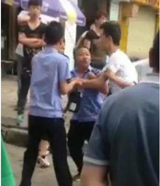 付某（右）與城管執(zhí)法人員廝打在一起。