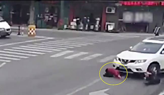 圖為小姑娘被卷進(jìn)車輪下瞬間。