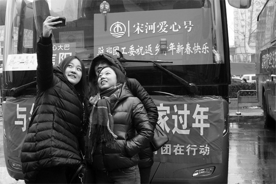 昨天上午8時(shí)，鄭州正道中環(huán)百貨廣場(chǎng)，準(zhǔn)備回家的老鄉(xiāng)在愛(ài)心大巴車前合影留念