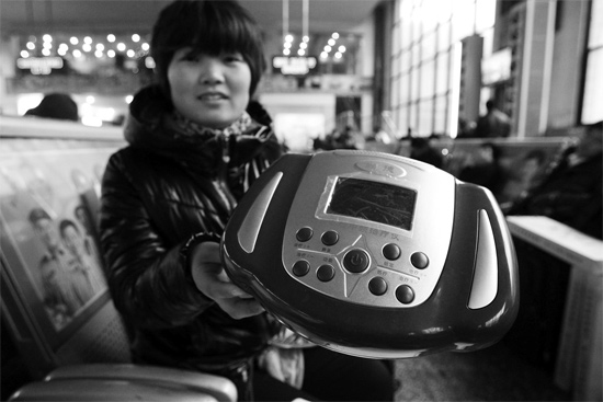 火車站候車室，李女士向記者展示她準備孝敬父母的按摩儀