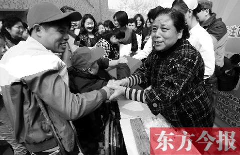 昨日，鄭大四附院的大樓前，“面人鄭”鄭玉芬（右）向前來(lái)捐款的殘疾人表示感謝
