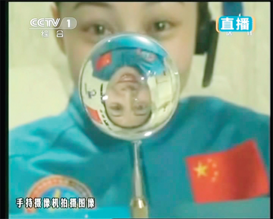 王亞平的倒影出現(xiàn)在水球中。新華社發(fā)（視頻截圖）