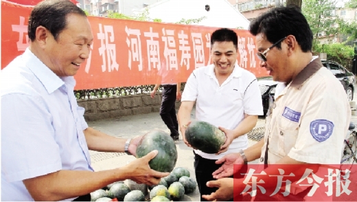 河南福壽園區(qū)域總經(jīng)理吳正宗（左一）、東方今報(bào)發(fā)行中心副總監(jiān)王路喜（中）在街頭給市民送瓜