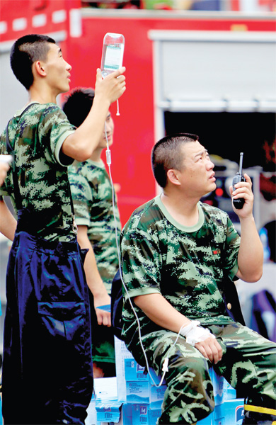 火場外，被消防戰(zhàn)士稱為“李大隊”的救援人員掛著吊瓶現(xiàn)場指揮