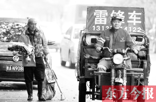 鄭州市商城路，一名環(huán)衛(wèi)工懷抱著剛剛收到的毯子，目送“雷鋒哥”孫德坤離開