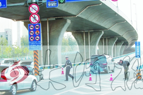 交警在東風(fēng)路從北向南上橋口處擺上反光錐，間歇放行