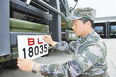 駐京某部上士高振超正在認(rèn)真更換新式軍車號(hào)牌?！　　”緢?bào)記者　尹　航攝