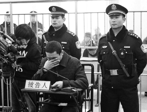 庭審中,29歲的李軍低著頭。
