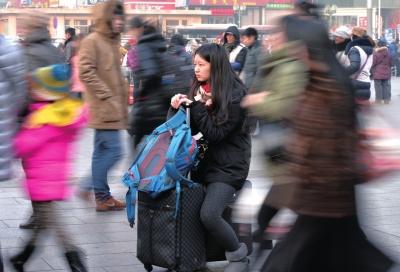 春運(yùn)首日，北京站客流量明顯增多，一名女孩在人流中等待進(jìn)站。