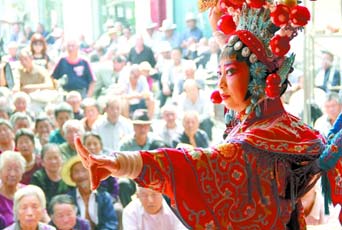 圖為8月15日戲曲演員在“流動(dòng)舞臺(tái)車”上表演傳統(tǒng)地方戲《穆桂英下山》。