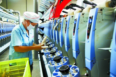 7月3日，在鄧州市永泰棉紡有限公司電腦控制全自動紡紗車間，紡織工人正在生產(chǎn)棉紗。