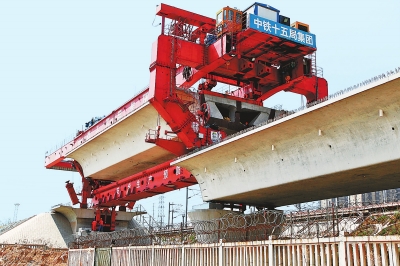 建設(shè)者們操縱巨型起重機(jī)在吊放橋墩。記者鄧放攝