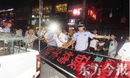 7月8日晚，鄭州市商城路一家占道經(jīng)營的攤販招牌被執(zhí)法隊(duì)員“登記保存”