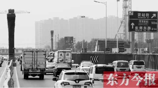 盡管是周六,可因車道縮減原因,機(jī)動(dòng)車依然排起了長隊(duì),通行緩慢。