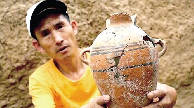 　　考古工作人員展示出土的仰韶文化時(shí)期代表性彩陶。