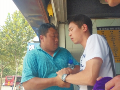 記者正查看照片，突遭藍(lán)衣男強(qiáng)搶手機(jī)。