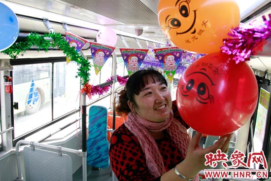 鄭州快速公交B3區(qū)間線車長李鵬云在車廂里懸掛氣球，布置圣誕車廂，營造歡樂圣誕氛圍