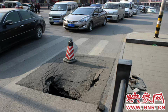 南陽路農(nóng)業(yè)路出現(xiàn)深坑，近看是因?yàn)闉r青充當(dāng)窨井蓋所致