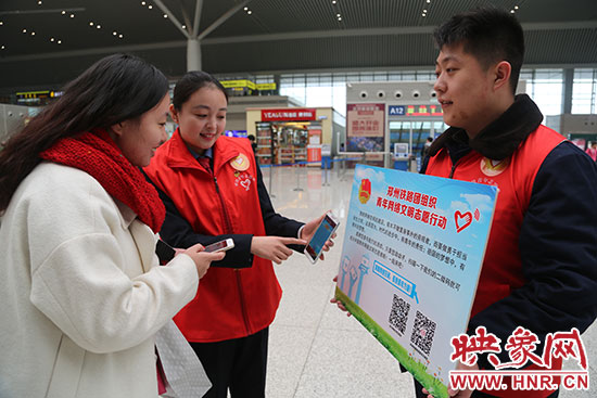 志愿者為旅客講解“網(wǎng)絡文明志愿”的行動內(nèi)容。
