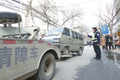 聯(lián)合執(zhí)法人員將市民舉報的違法占道經營車輛拖走暫扣