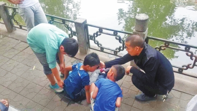 男孩被救出后，圍觀群眾幫他控水換衣服。