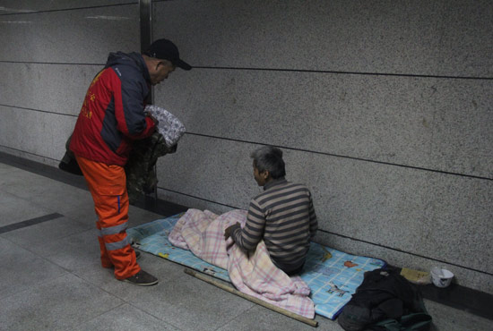 在鄭州一處地下通道，孫德坤挑了幾件衣服送給了流浪者