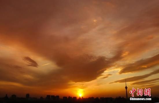 12月8日下午，強(qiáng)烈的西北風(fēng)光臨北京，吹散了籠罩全城上空的霧霾，冬日罕見的艷麗晚霞映紅了半邊天。