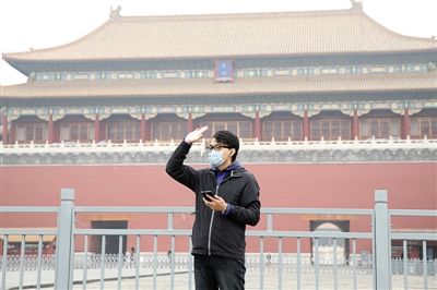 11月1日，北京大部分地區(qū)重度污染，一名游客戴著口罩在午門前揮手跟朋友打招呼。 實(shí)習(xí)生 王飛 攝