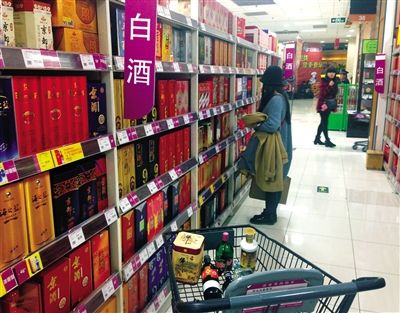 顧客在商場的高檔白酒貨架前駐足挑選。春節(jié)臨近，受“禁令”影響，以高檔白酒為代表的節(jié)日禮品市場面臨考驗。記者 王遠(yuǎn)征 攝