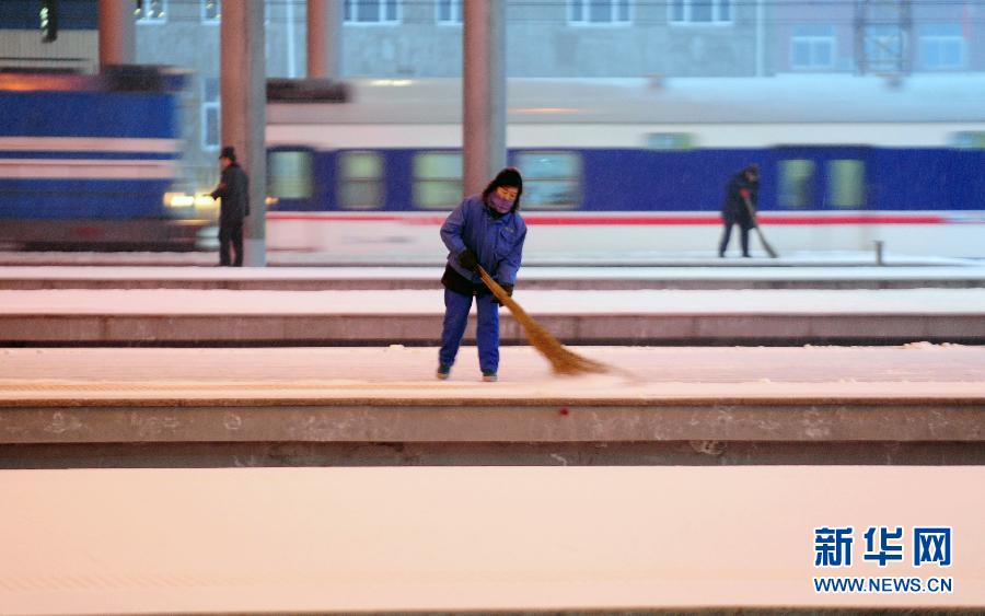 1月19日，沈陽北站的工作人員在清掃站臺積雪。