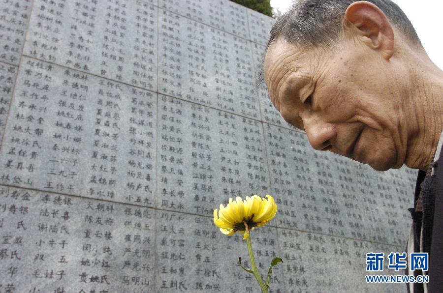 2006年4月5日，74歲的南京大屠殺幸存者佘子清手捧鮮花，祭奠被日軍殺害的母親。