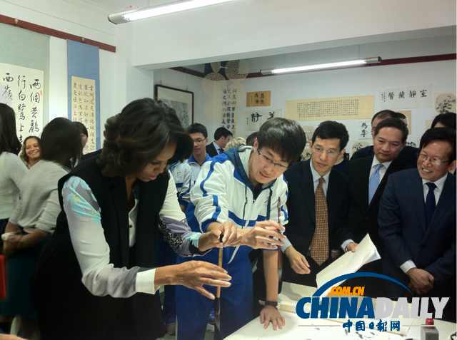 北京時間3月21日，美國第一夫人米歇爾參觀北師大二附中時，與學(xué)生一起練習(xí)書法。