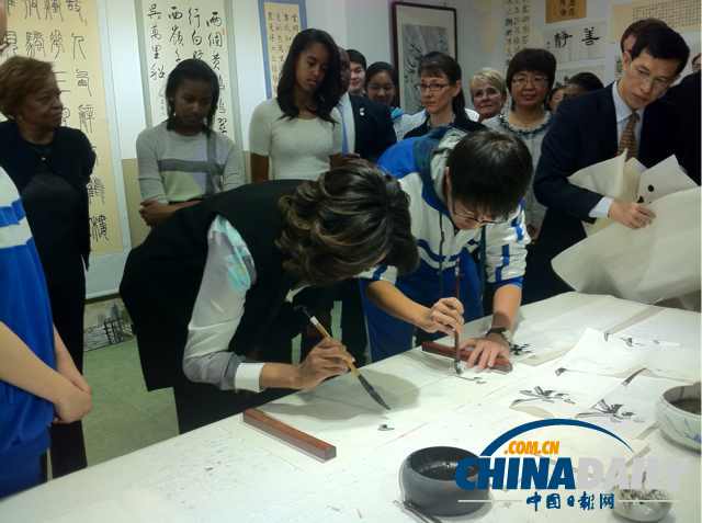 　北京時間3月21日，美國第一夫人米歇爾參觀北師大二附中時，與學(xué)生一起練習(xí)書法。