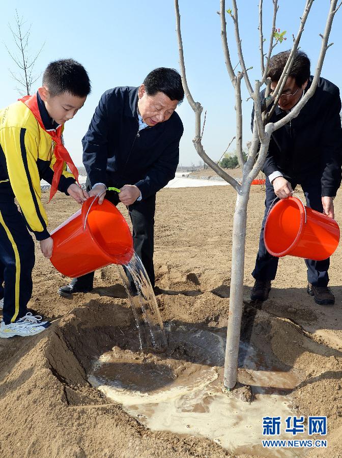 這是習(xí)近平同大家一起給剛栽下的樹(shù)苗澆水。